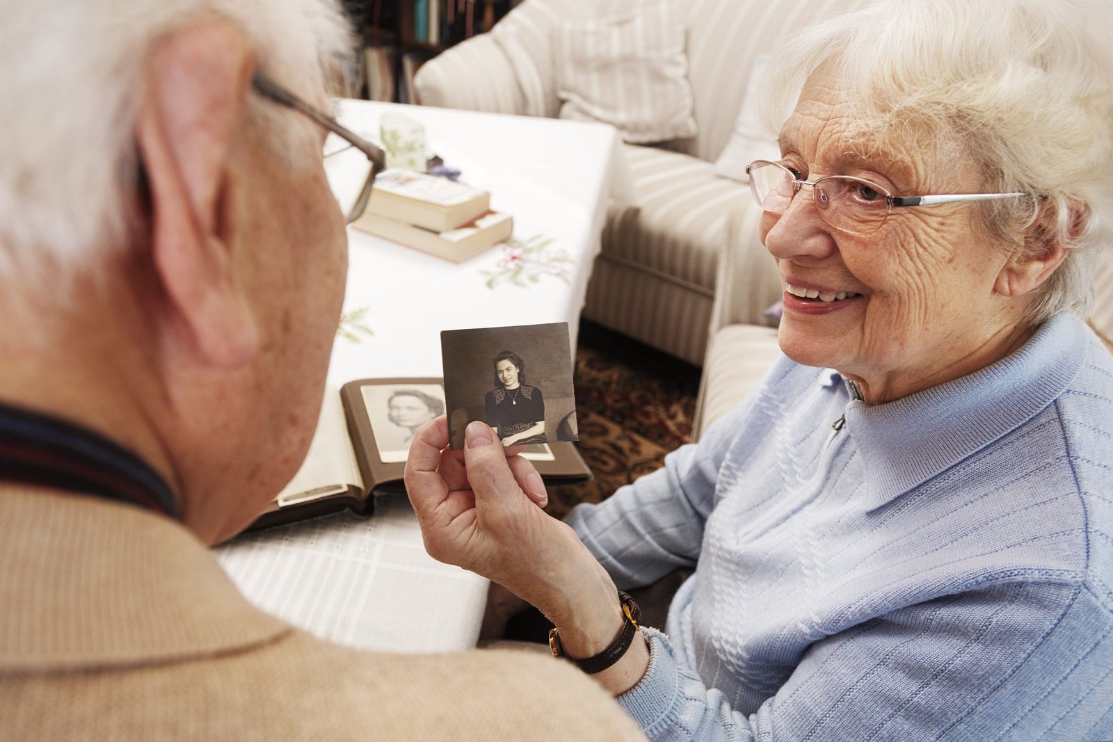 Senior woman showing her husband old photograph of herself